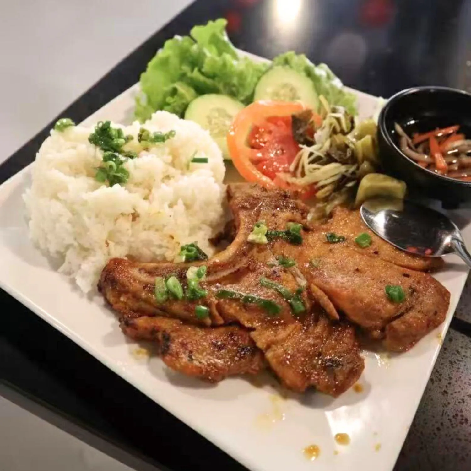 Grilled pork chop with jasmine rice and fresh vegetables at Pho Luu Escondido - Vietnamese Cuisine Restaurant in Escondido